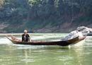 Man paddling longboat on Mekong River